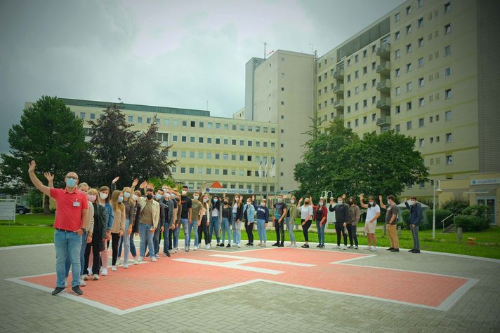 Auszubildende sowie Kursleitung vor dem Klinikum Saarbrücken stehend auf dem Hubschrauberlandeplatz.