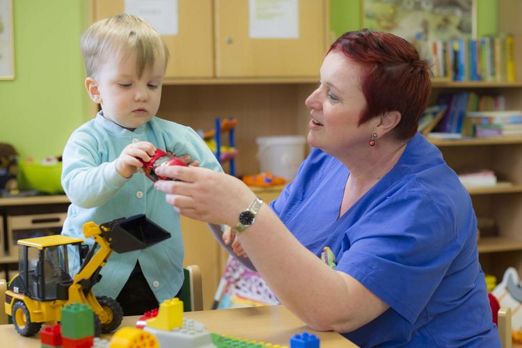 Pflegefachkraft im Klinikum Saarbrücken spielt mit Kind