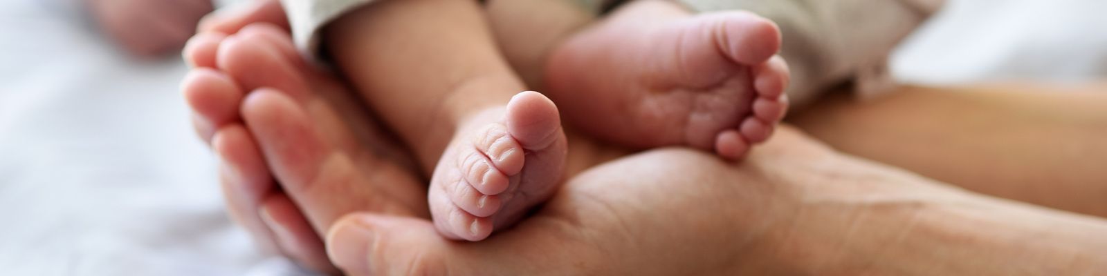 Hand hält Babyfüße im Klinikum Saarbrücken auf dem Winterberg Geborgen_Babyfuesse_Slider.jpg