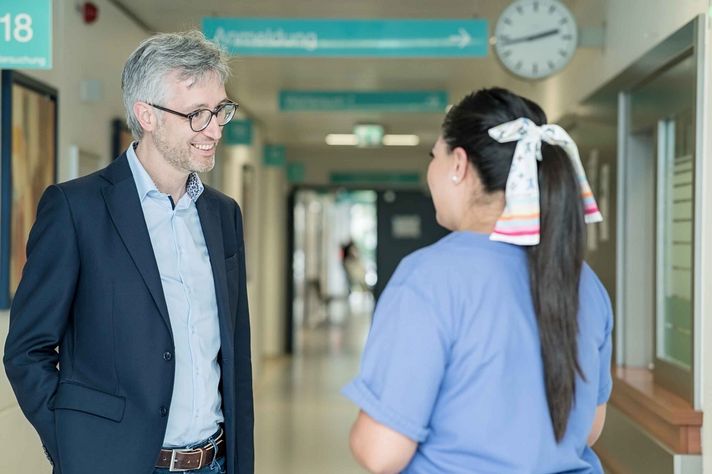 Thomas Hesse, Personaldirektor im Klinikum Saarbrücken, im Gespräch mit einer Pflegefachkraft.