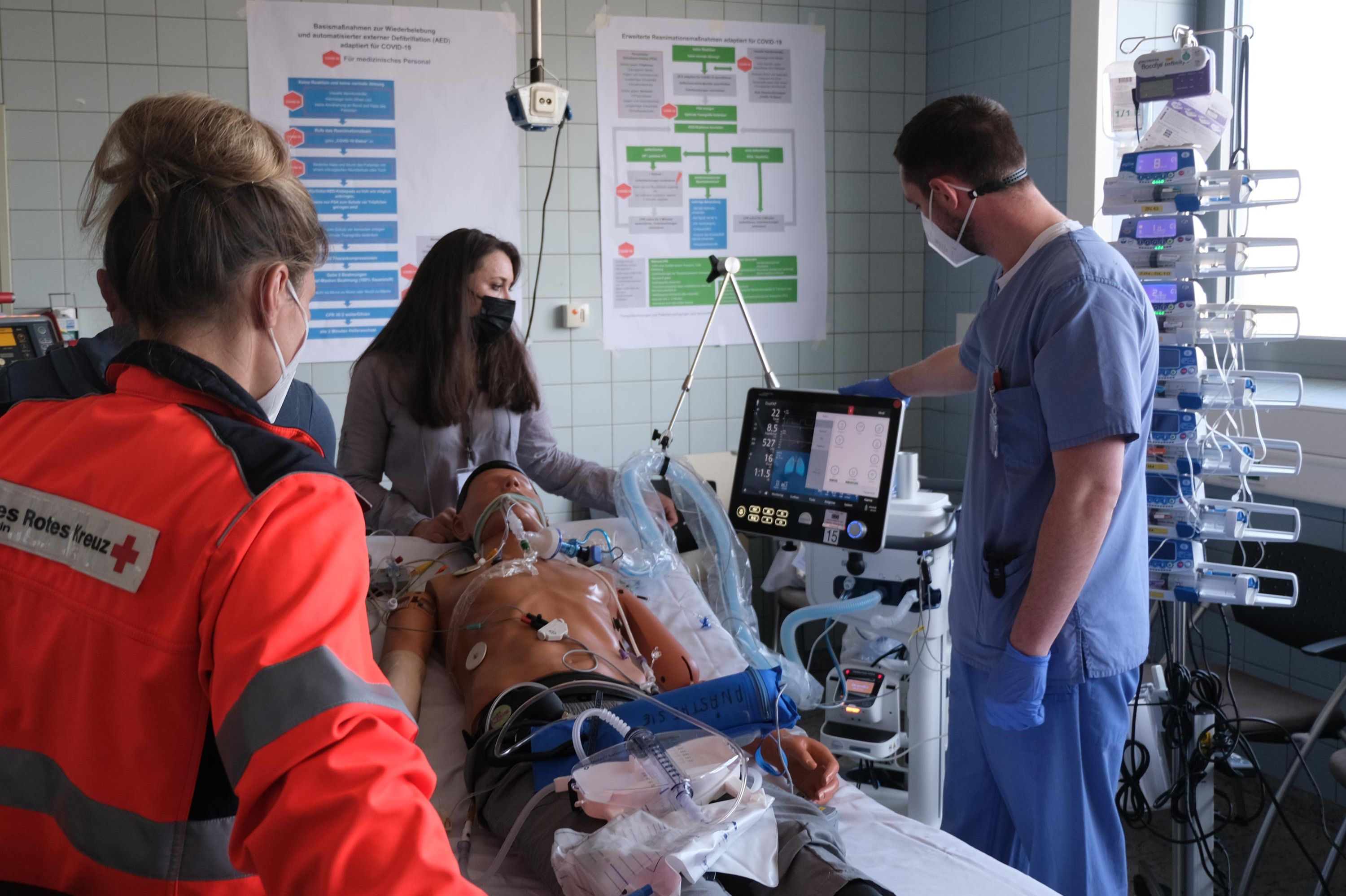 Kolleginnen und Kollegen üben den Transport eines intensivpflichtigen Patienten an einer Puppe