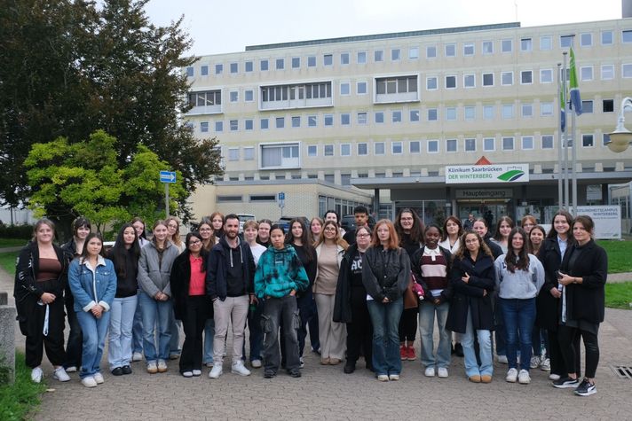 Gruppenfoto des neuen Kurses GP/GP+Päd 25–28 vor dem Haupteingang. 