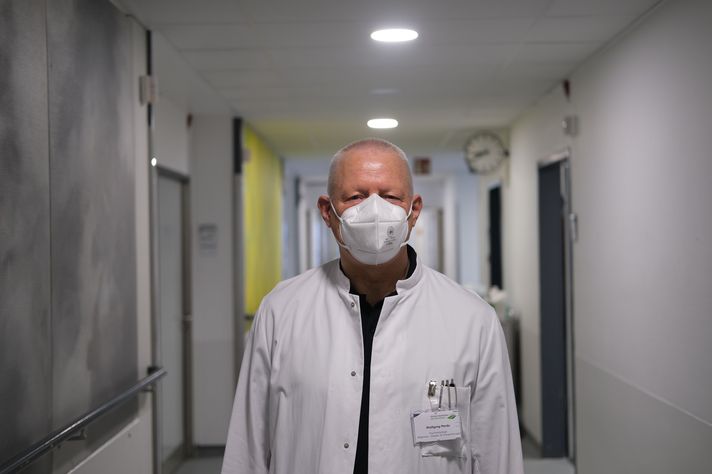 Wolfgang Merda steht in einem Klinik-Flur und schaut in die Kamera