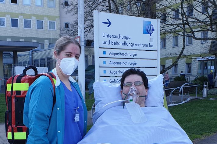 Patient Werner Geyer und Gesundheits- und Krankenpflegegerin mit Fachweiterbildung für Intensivpflege und Anästhesie vor dem Klinikum Saarbrücken