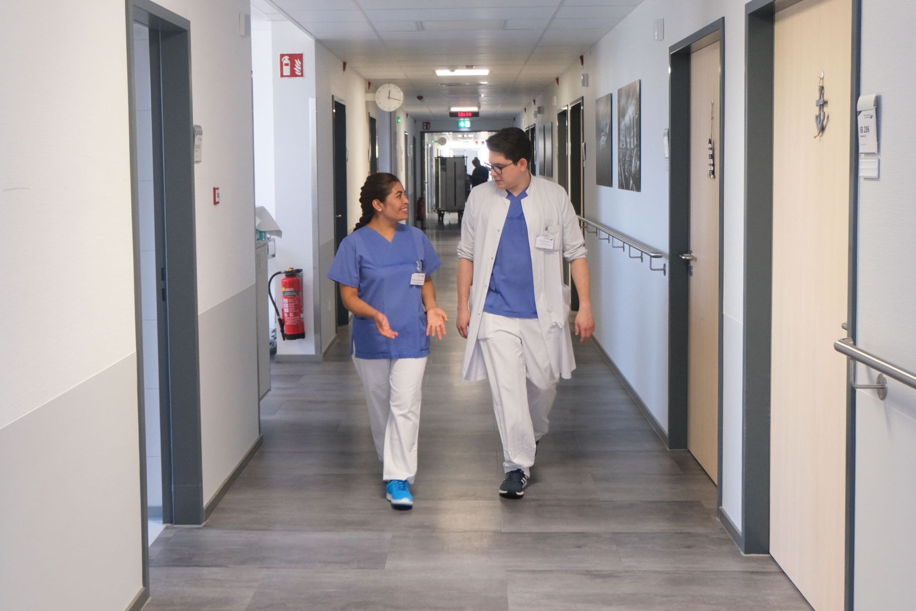 Internationale Fachkräfte im Klinikum Saarbrücken: Arzt und Pflegekraft unterhalten sich im Flur im Gehen