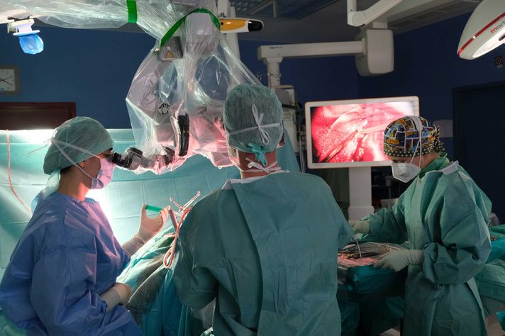 Operateure am OP-Tisch im Klinikum Saarbrücken während einer neurochirurgischen Operation mit Hilfe eines Hochleistungsmikroskops.