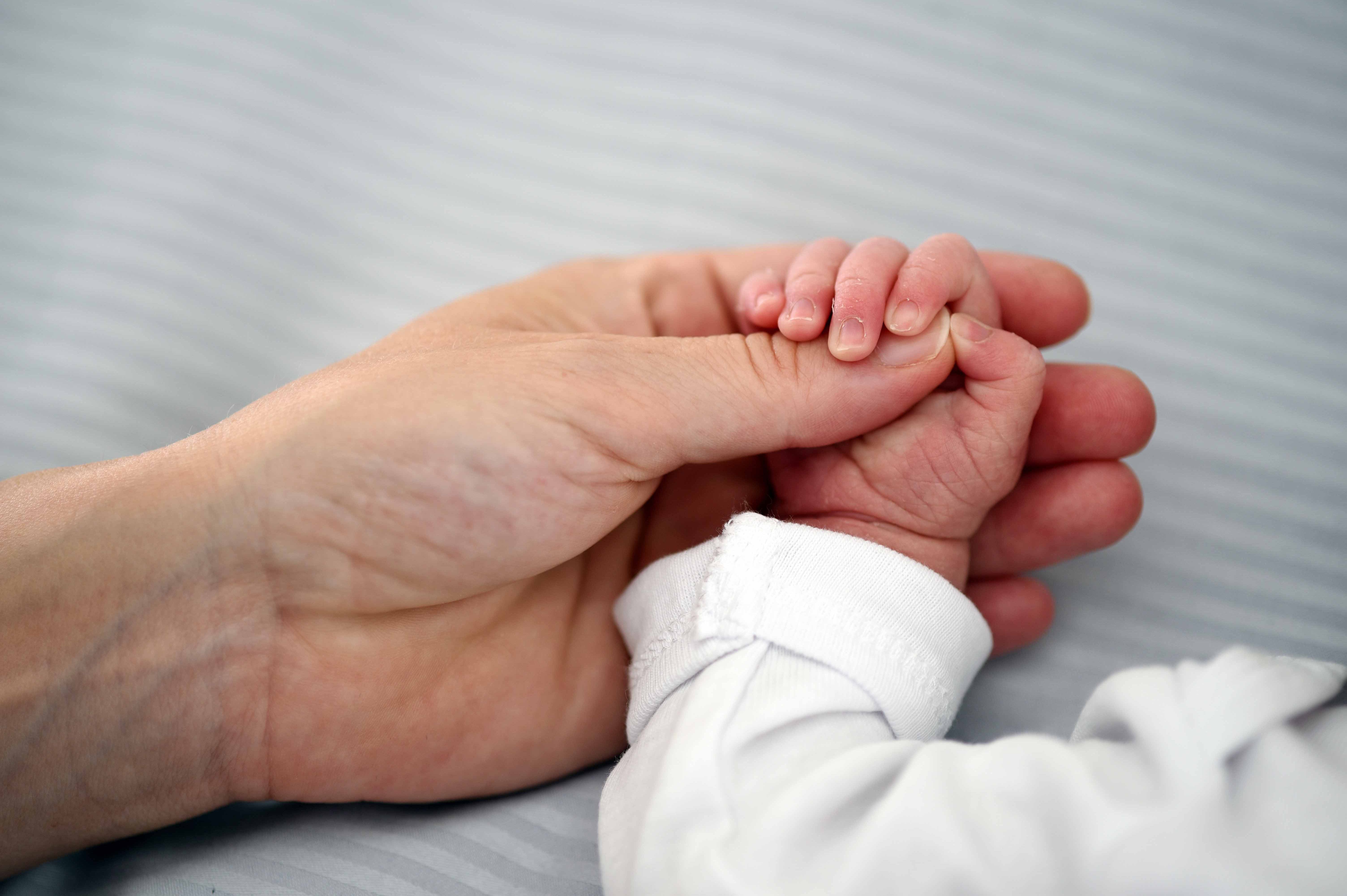 Eltern halten Babyhand in ihrer Hand im Klinikum Saarbrücken