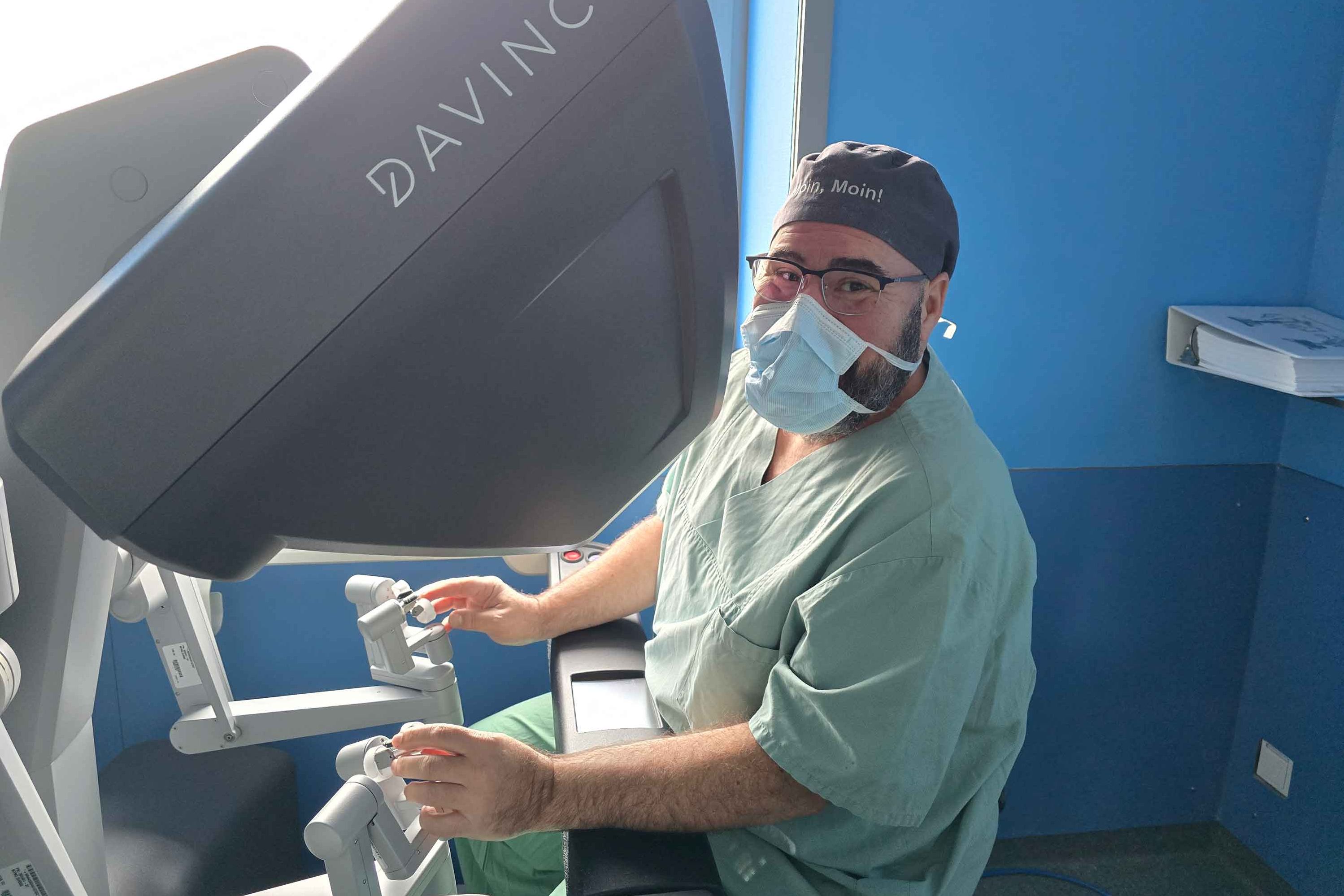Dr. Dr. habil Gregor Stavrou sitzt an einer Konsole des Robotik-Systems DaVinci.