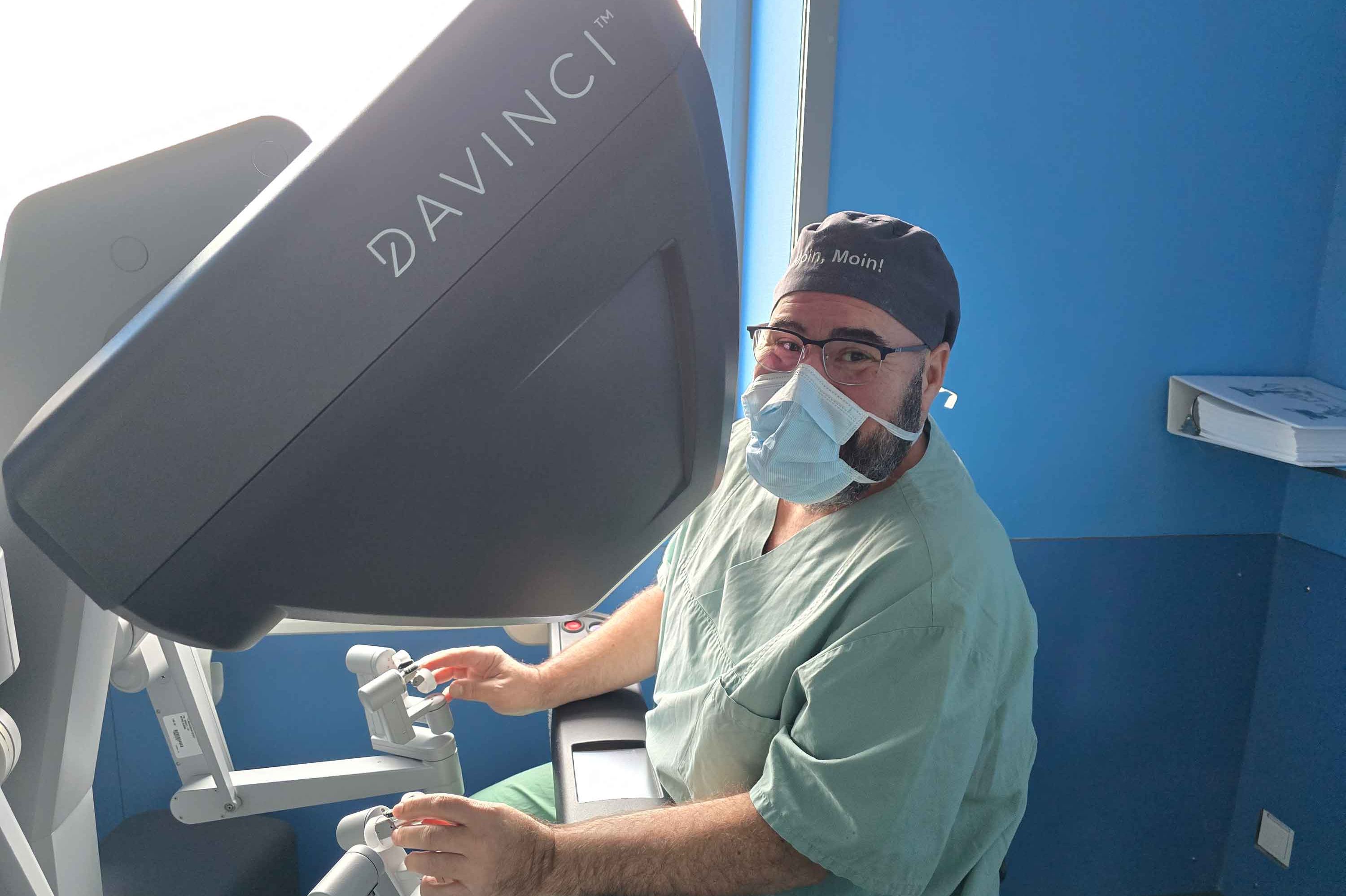 Dr. Dr. habil Gregor Stavrou sitzt an einer Konsole des Robotik-Systems DaVinci. 