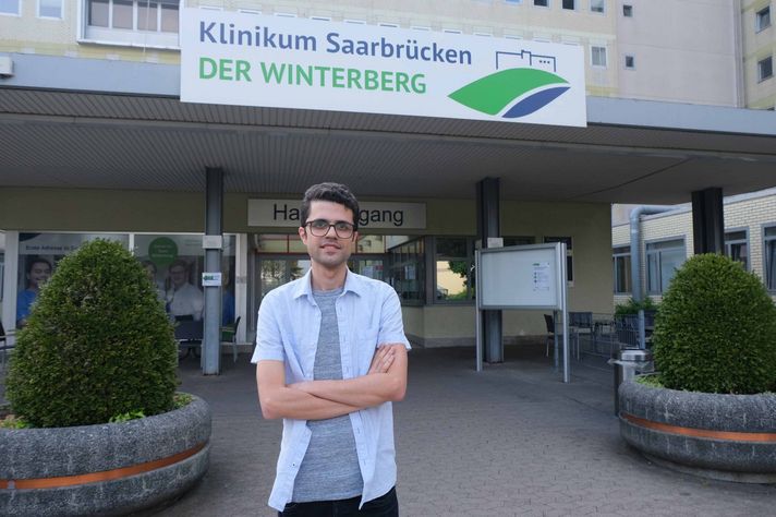Dr. Mahmoud Lotfinia steht vor dem Haupteingang des Klinikums
