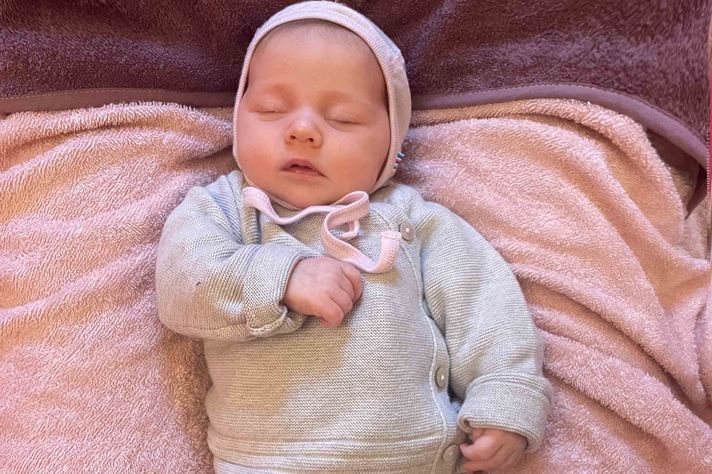 Die neugeborene Stella liegt schlafend auf einer rosa Decke