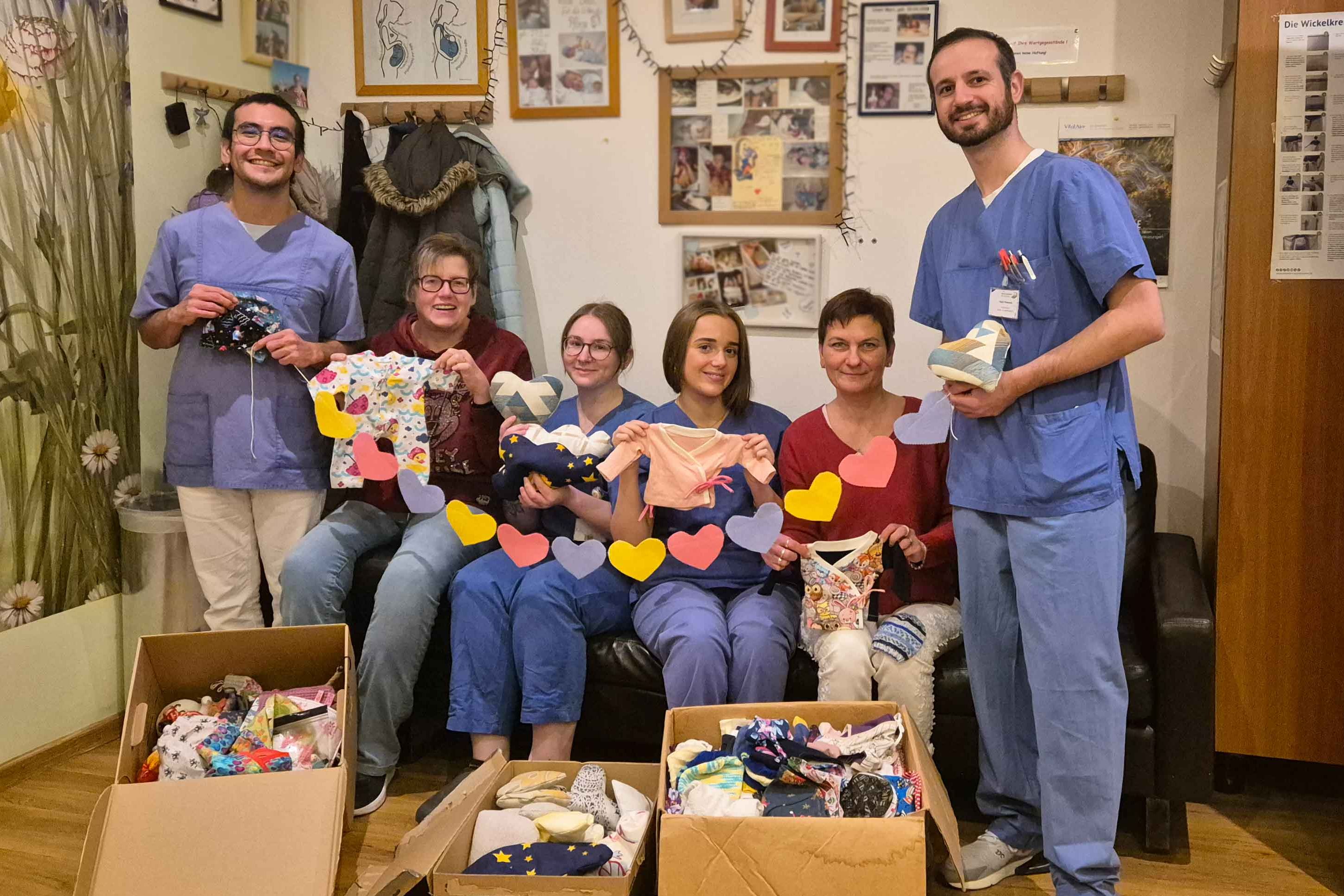 Betty Mayer (sitzend rechts) und Annemarie Klos (sitzend links) von "Nähen für ein Kinderlächeln" haben dem KIS-Team rund 550 liebevoll gestaltete Spenden übergeben.