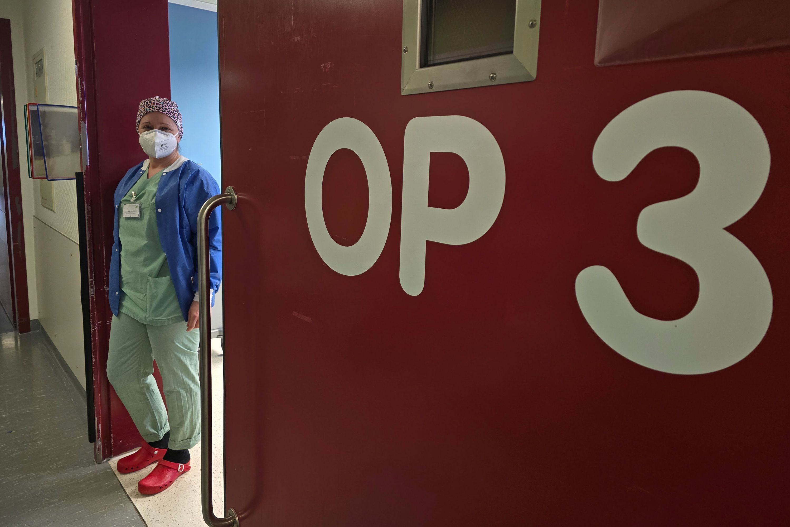 Katja Schmitt steht im OP-Bereich vor dem Eingang von OP-Saal 3.