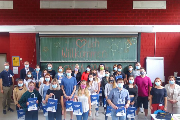 Gruppenfoto neue Schüler im Klinikum Saarbrücken vor Tafel "Willkommen"