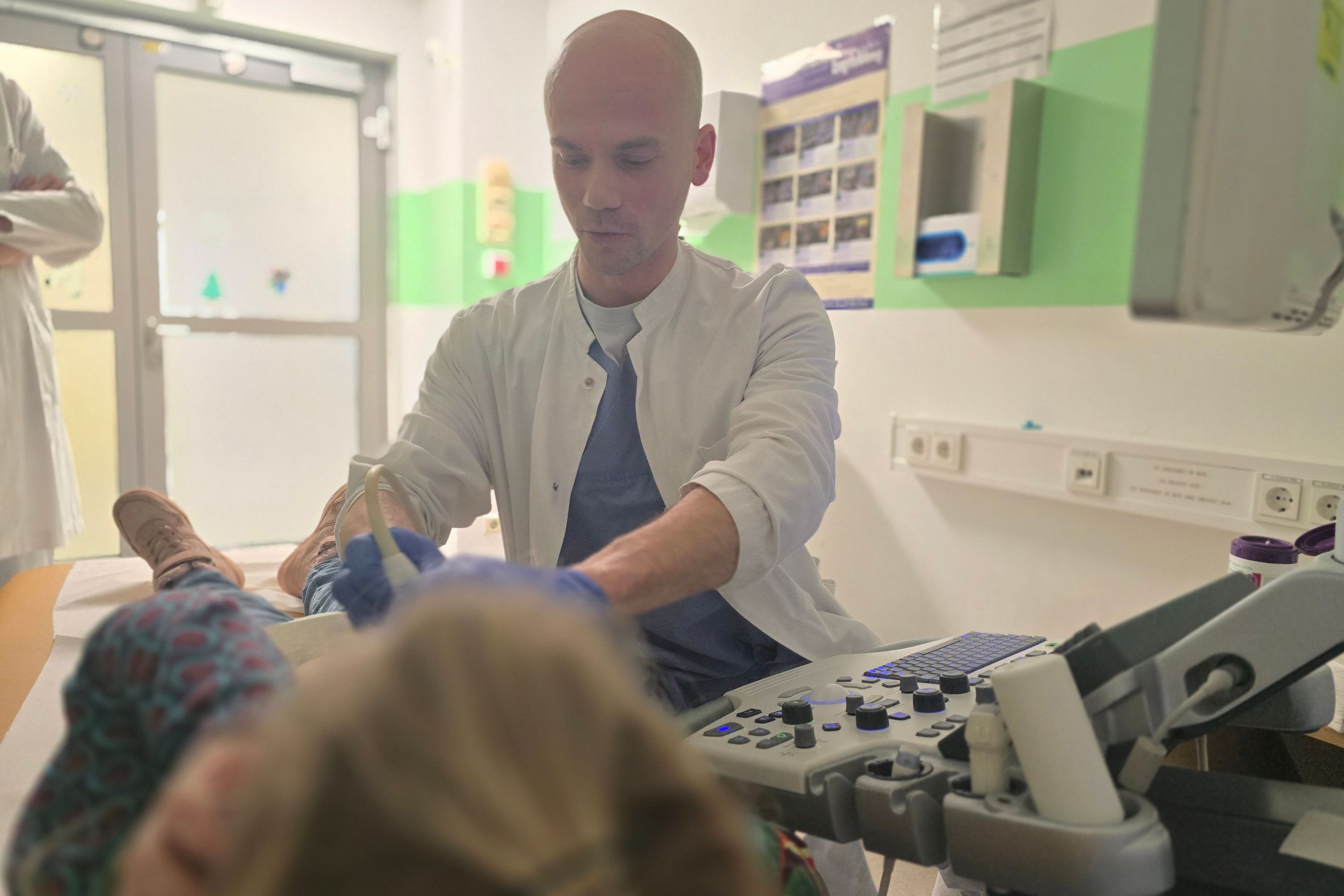 Ein Kinderarzt macht einen Ultraschall am Bauch eines Kindes.