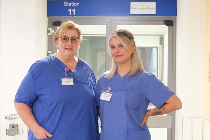 Martina Sander (links), Stationsleitung der Aufnahmestation, und Darlene Klos, Stationsleitung der Kurzliegerstation, vor der Station 11 im Klinikum Saarbrücken