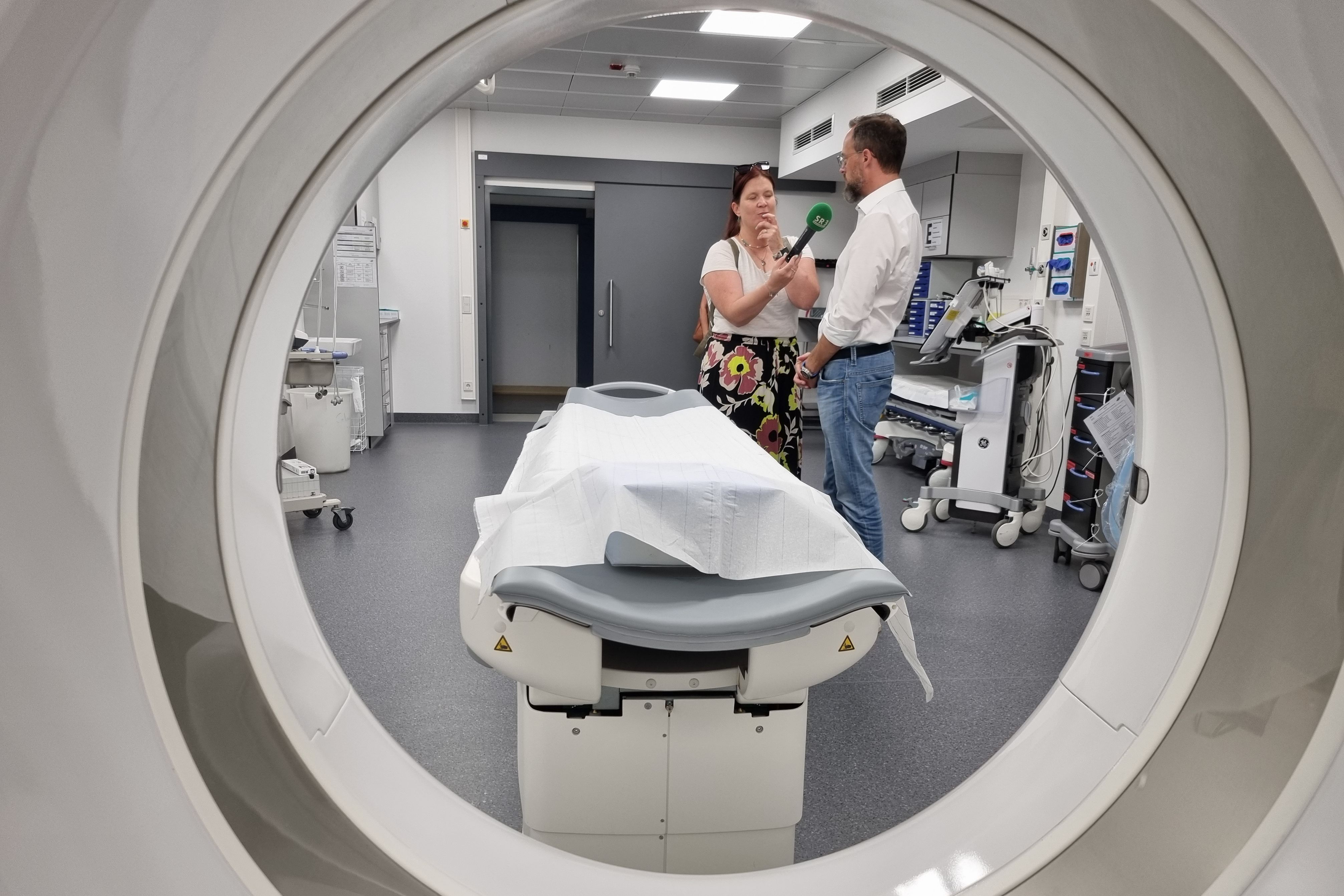 Dr. Christian Braun gibt ein Radio-Interview an SR3. Blick durch die CT-Röhre in den Schockraum.