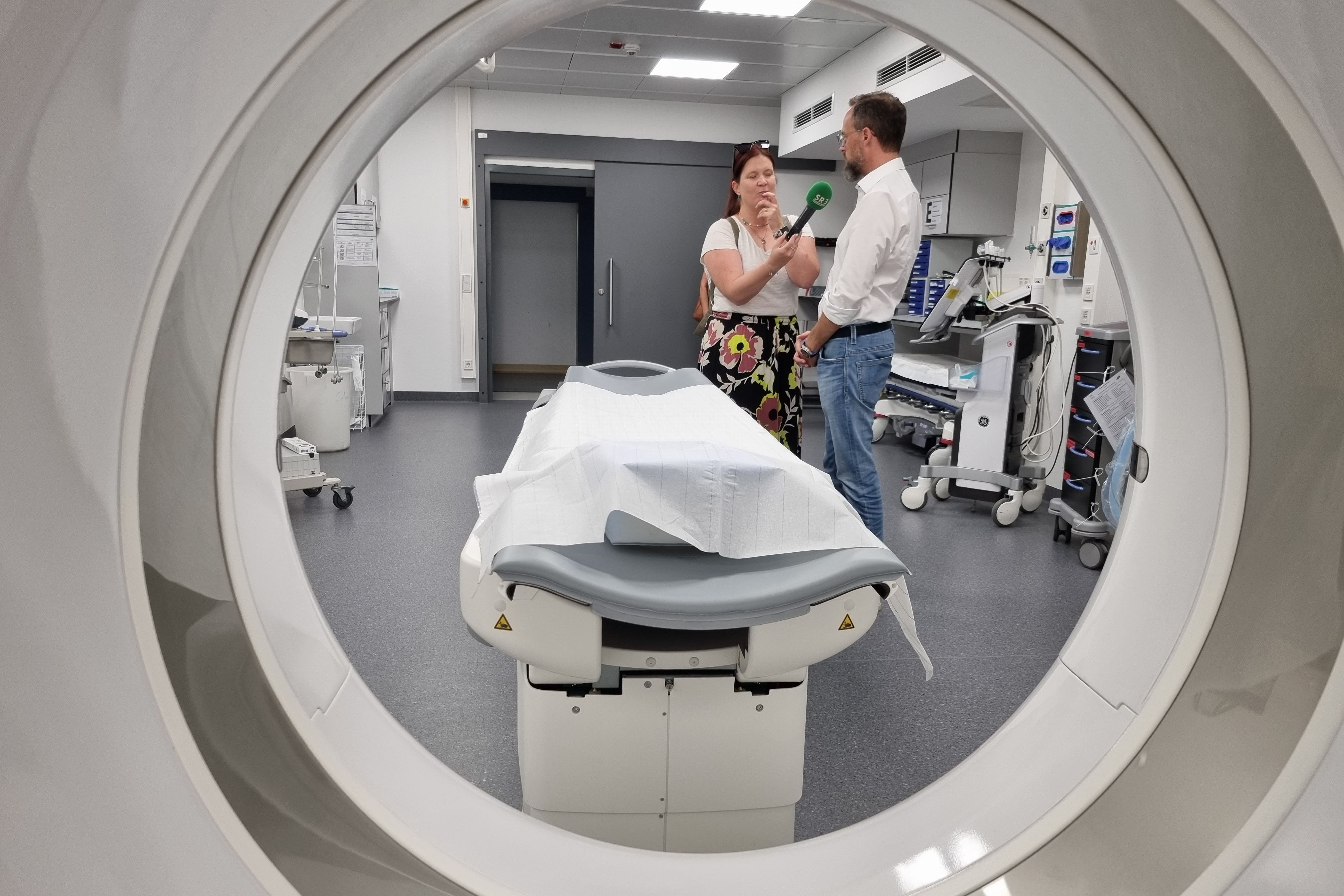 Dr. Christian Braun gibt ein Radio-Interview an SR3. Blick durch die CT-Röhre in den Schockraum.