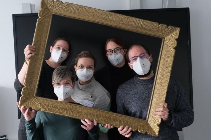 Fünf Lehrende der Schule für Gesundheitsfachberufe auf dem Winterberg posieren in einem Bilderrahmen