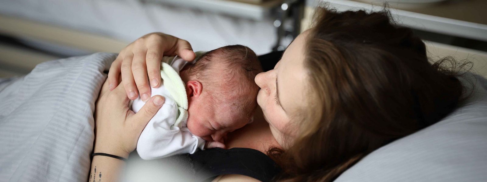 Eine Mutter mit einem Baby auf der Brust Slider_Elternschule_Mutter_Baby.jpg