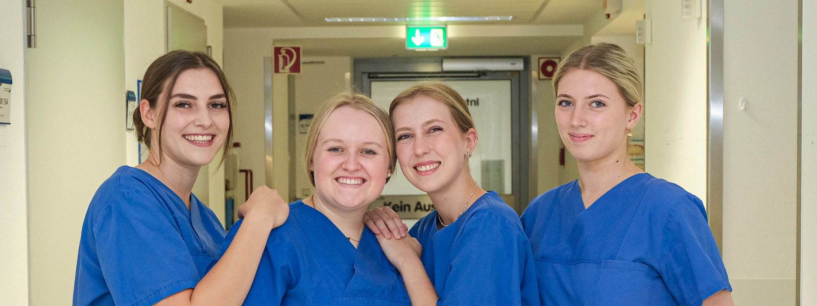 Gruppenaufnahme von vier Auszubildenden der vierjährigen Ausbildung zur Pflegefachfrau mit Fachweiterbildung Intensivpflege und Anästhesie auf dem Flur der Intensivstation 10 ZIN_Slider_2.jpg