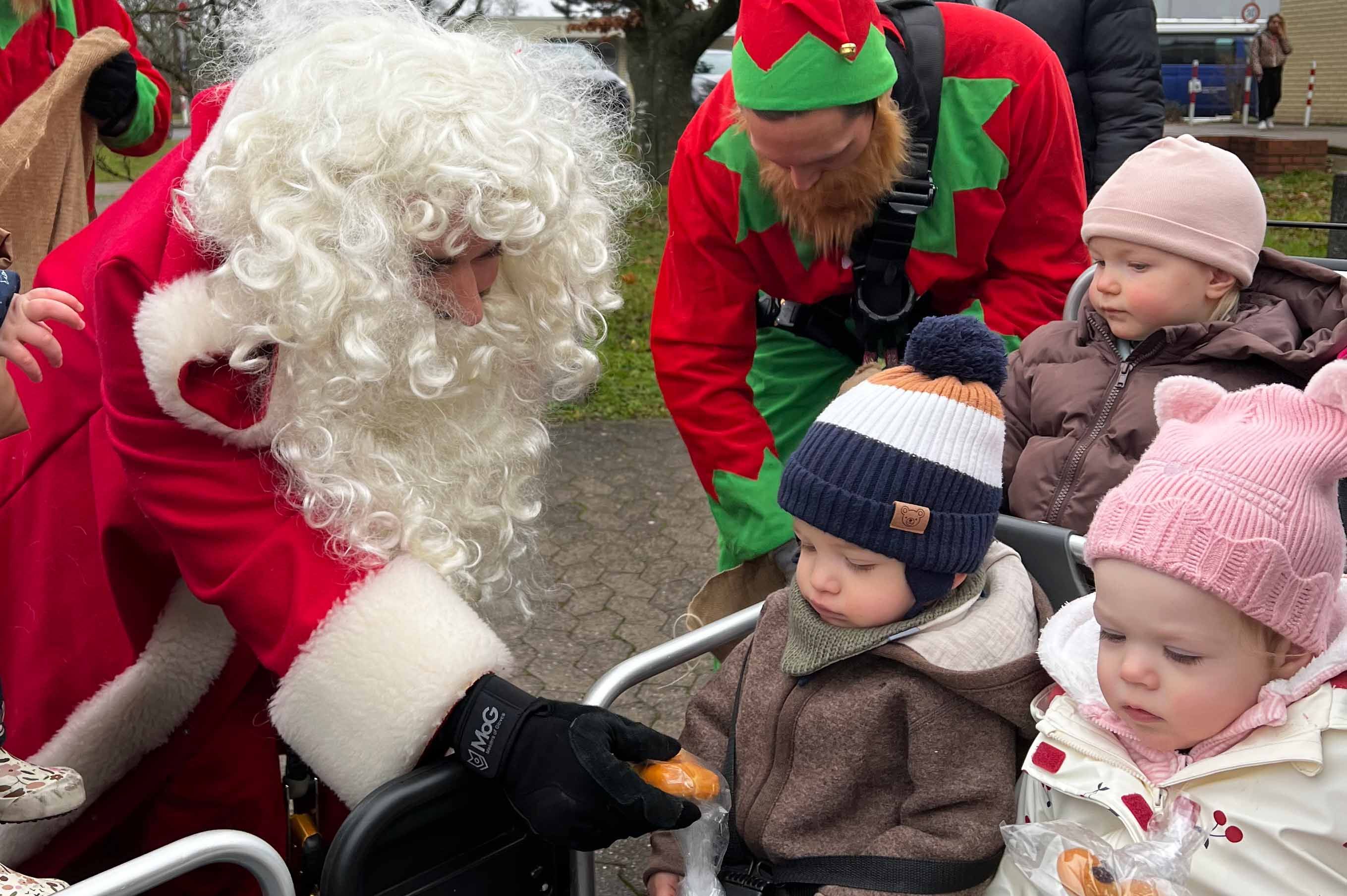 Der Weihnachtsmann verteilt Geschenke an die Kinder.