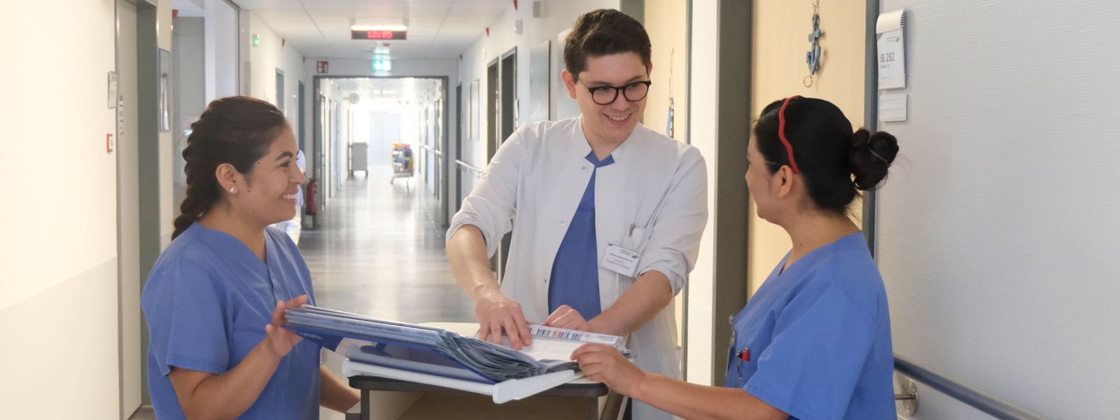 Visite im Klinikum Saarbrücken: Arzt bespricht mit zwei Pflegefachkräften Akte Arzt_Pflege_Visite_Slider.jpg