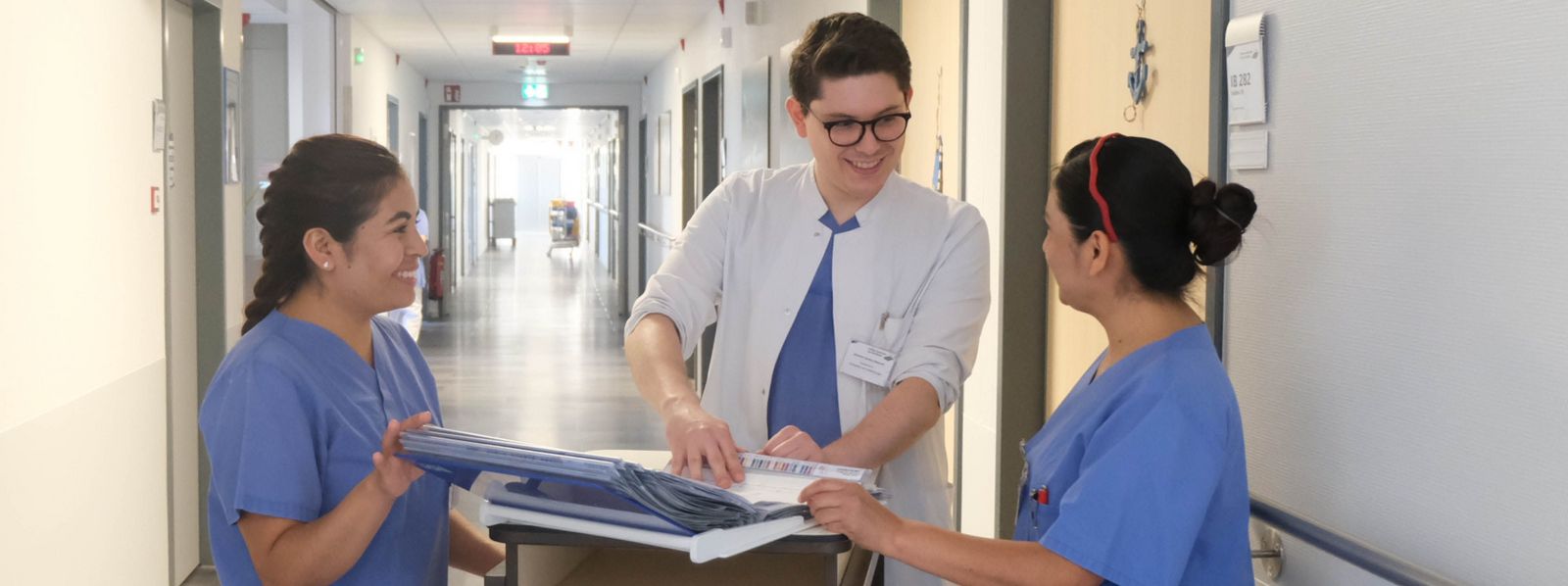 Visite im Klinikum Saarbrücken: Arzt bespricht mit zwei Pflegefachkräften Akte Arzt_Pflege_Visite_Slider.jpg