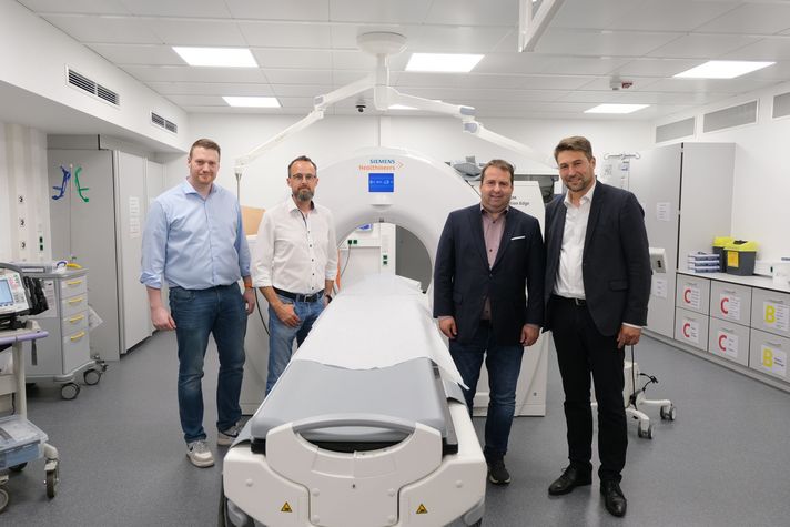 Tobias Raab (Aufsichtsratsvorsitzender), Dr. Christian Braun (Geschäftsführer und Ärztlicher Direktor Klinikum Saarbrücken), Gesundheitsminister Dr. Magnus Jung und Oberbürgermeister Uwe Conradt stehen bei der Einweihung des neuen Schockraums vor dem Computertomographen.