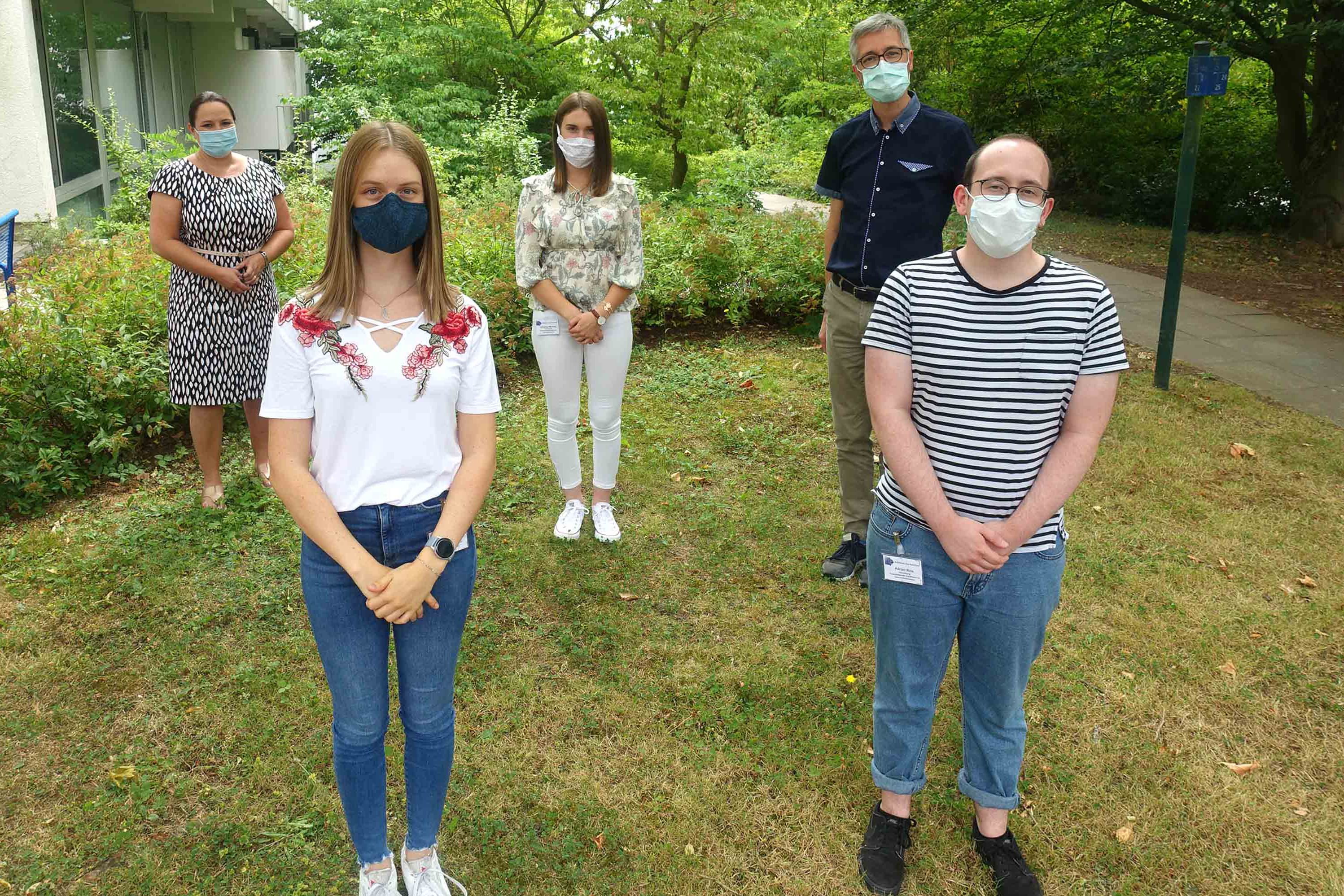 Verwaltungsazubis mit Personaldirektor im Grünen vor dem Klinikum