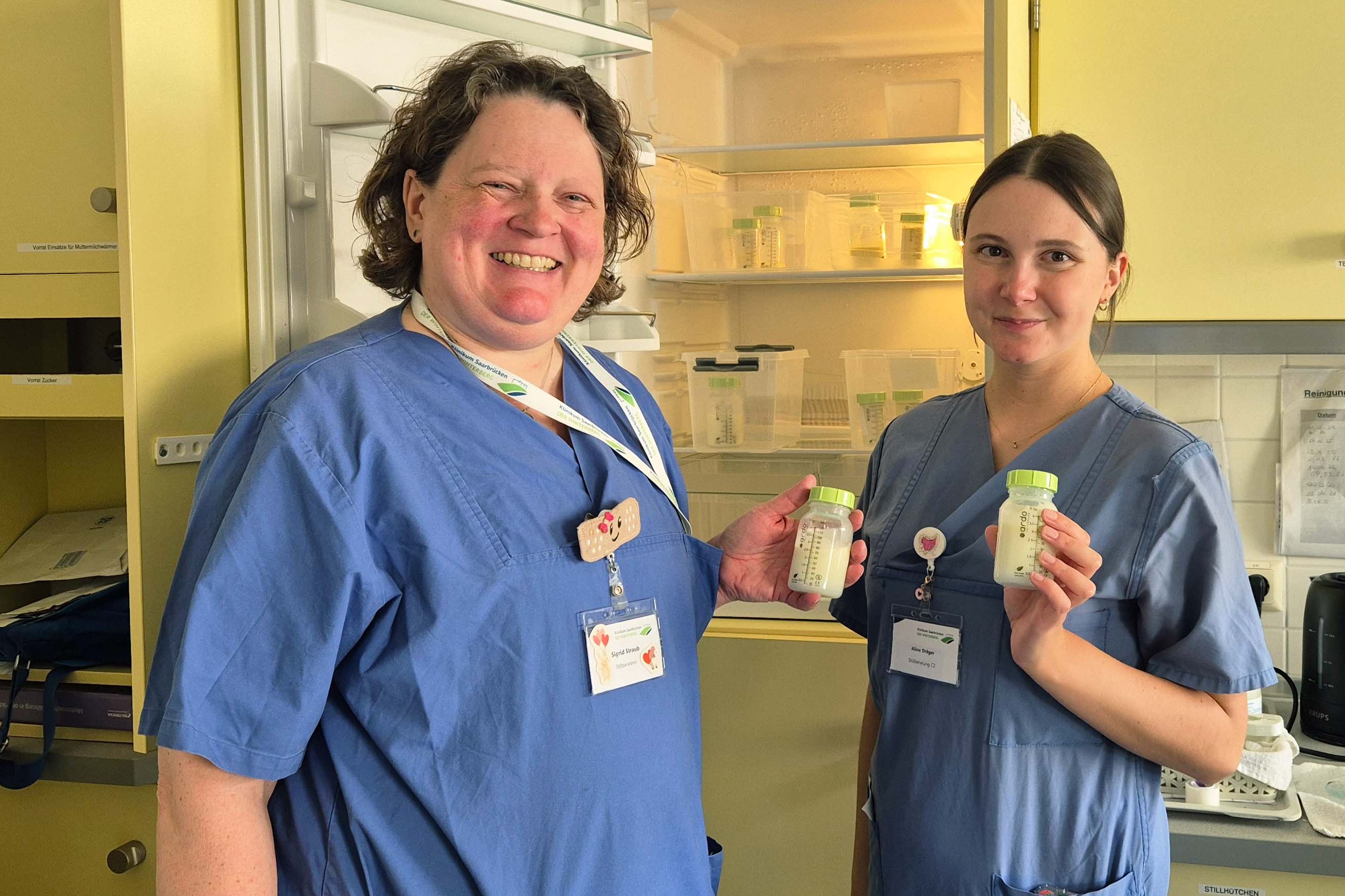 Sigrid Straub (links) und Alina Dräger mit gespendeter Muttermilch vor dem Frauenmilchkühlschrank auf Station C2.