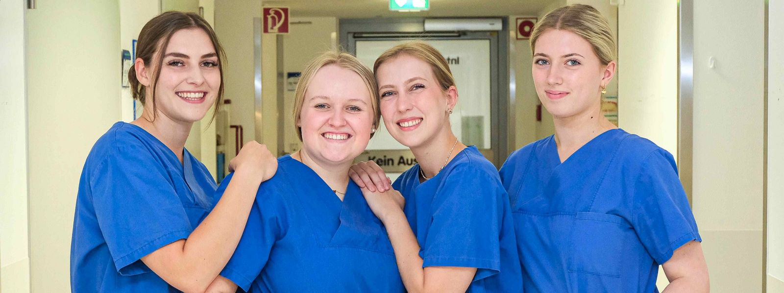 Ein Foto von vier Auszubildenden im Kasack, sie lachen alle in die Kamera Slider_Bildungszentrum_Schule_3.jpg