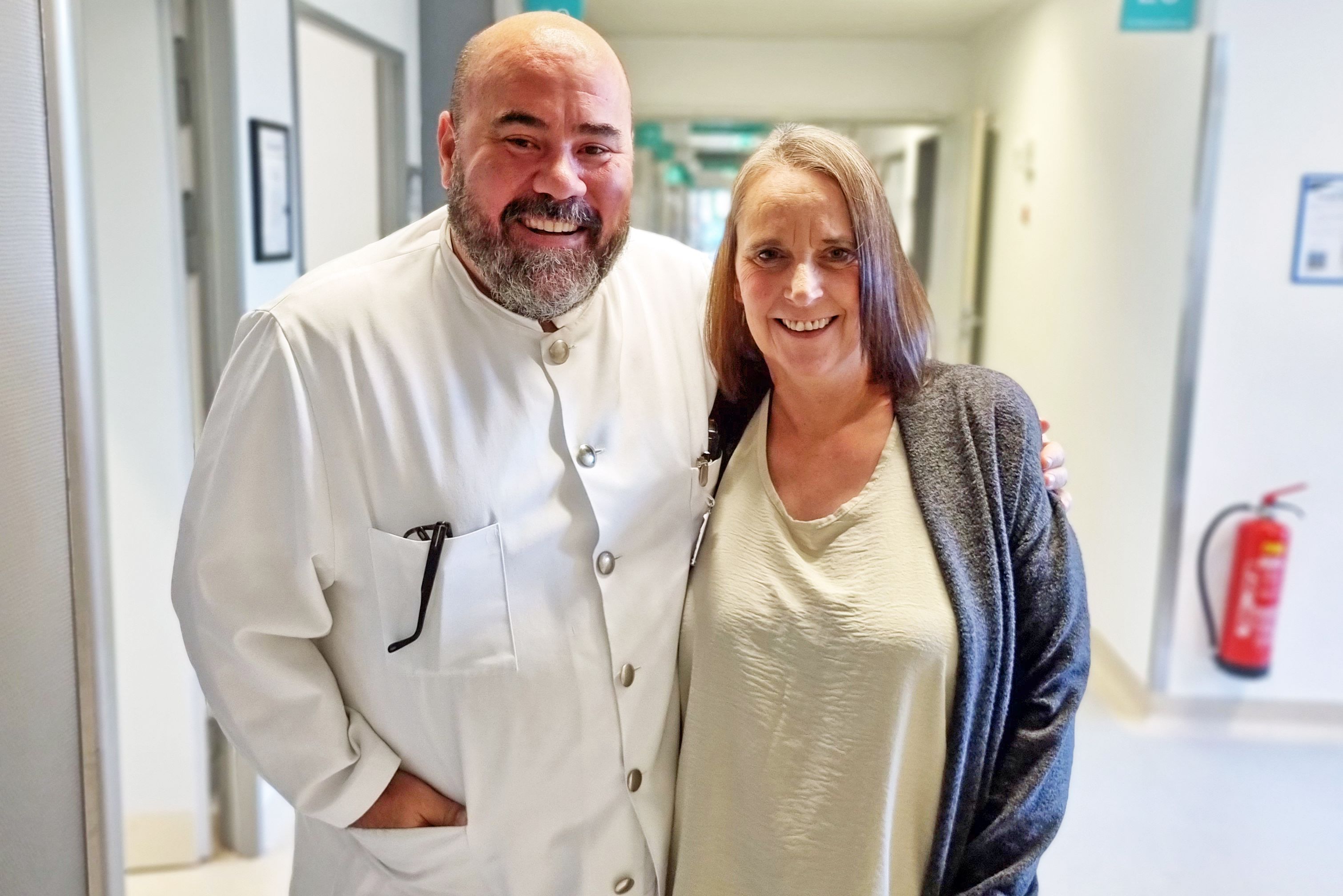 Chefarzt Dr. Dr. habil Gregor Stavrou und Patientin Michaela Hess im Flur des Untersuchungs- und Behandlungszentrums - nach geglückter Tumor-OP.