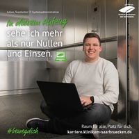 Julian sitzt in Aufzug mit einem Laptop auf dem Schoß. Über ihm steht: In diesem Aufzug sehe ich mehr als nur Nullen und Einsen