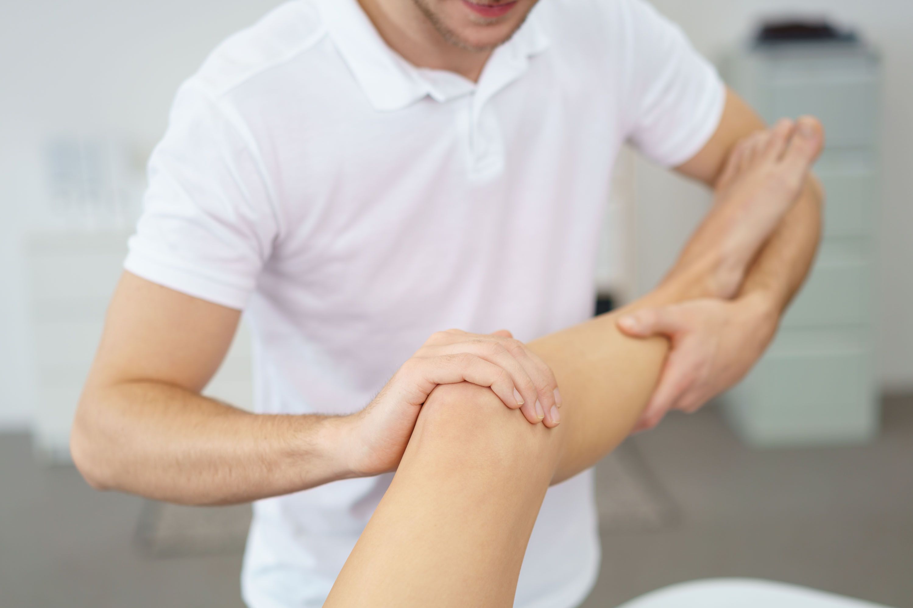 Therapeut untersucht das Knie einer Patientin (Foto: AdobeStock_97112656)