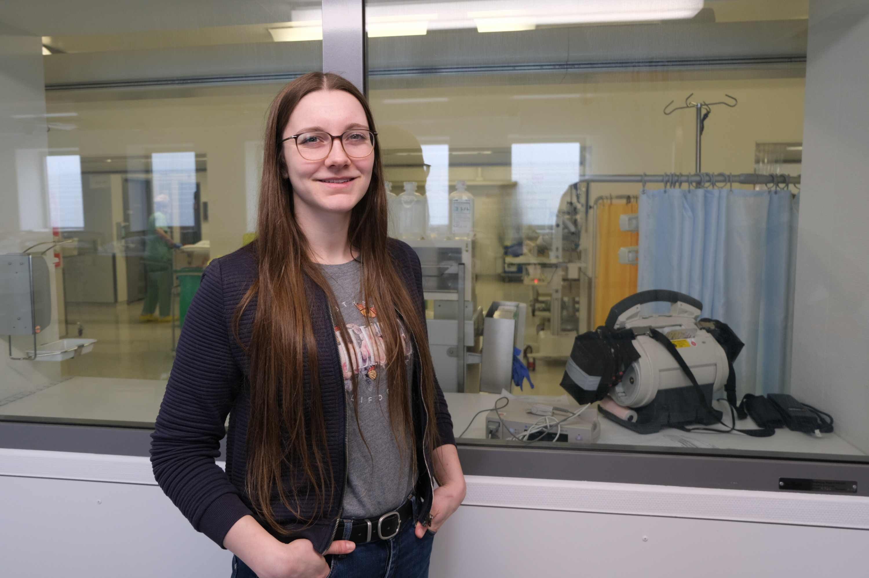 Die wissenschaftliche Mitarbeitern der htw saar, Lena Hupperich, steht in einem Flur, in dem es zu den OP-Sälen geht