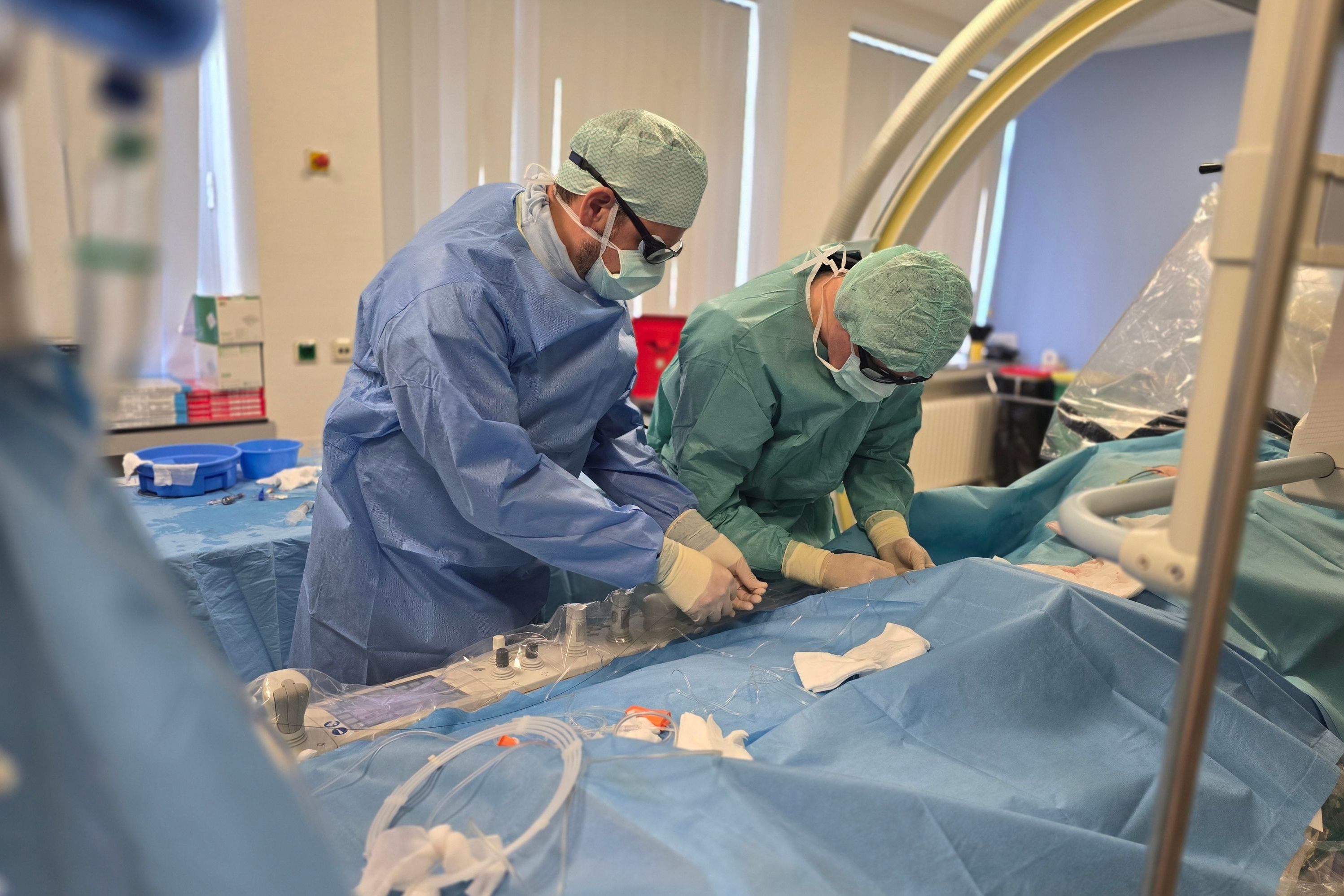 Zwei Neuroradiologen behandeln mit einem Kathetersystem ein Aneurysma.