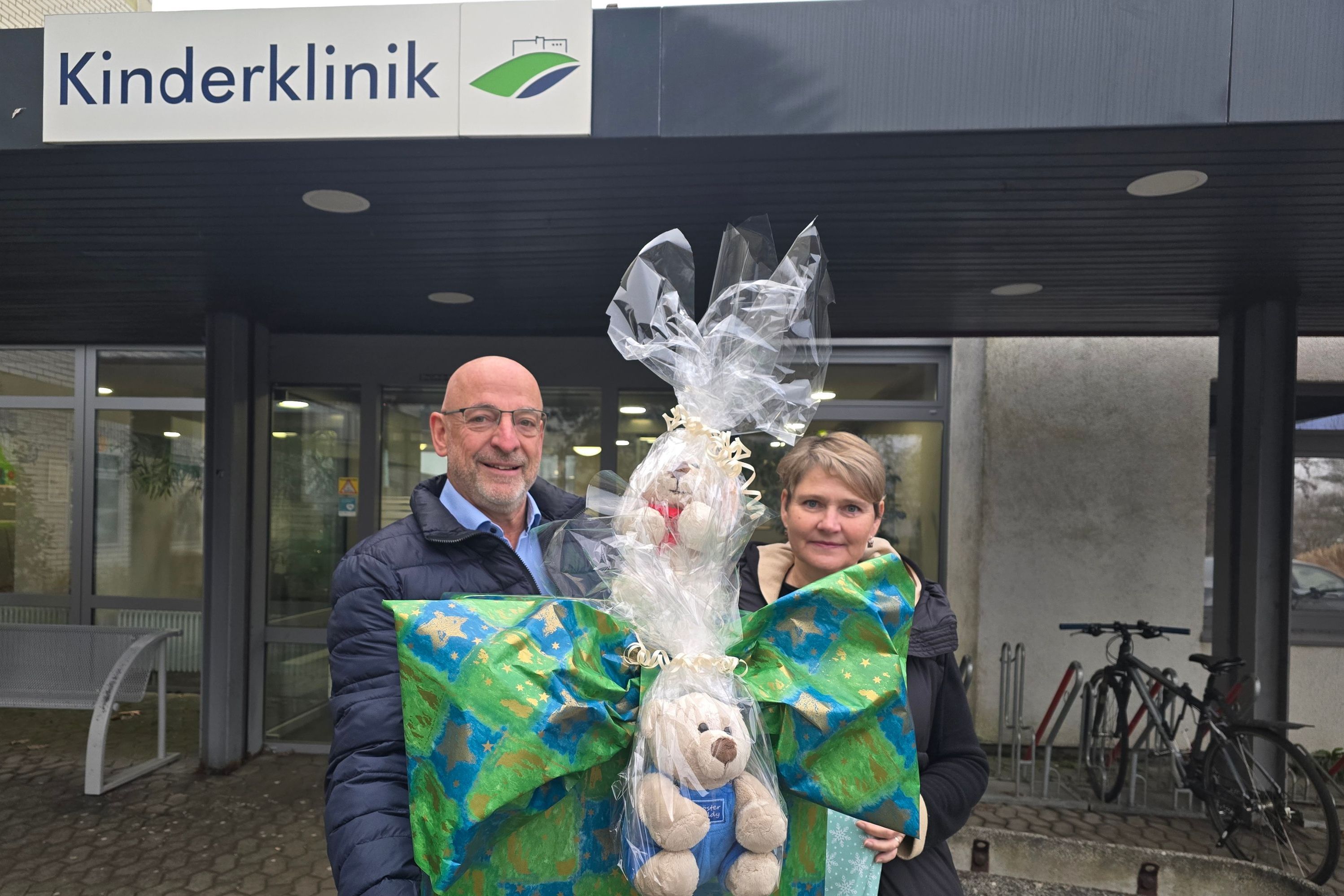 Peter Kayser und Jeannette Rappin vor der Kinderklinik mit ihrem großen Paket.