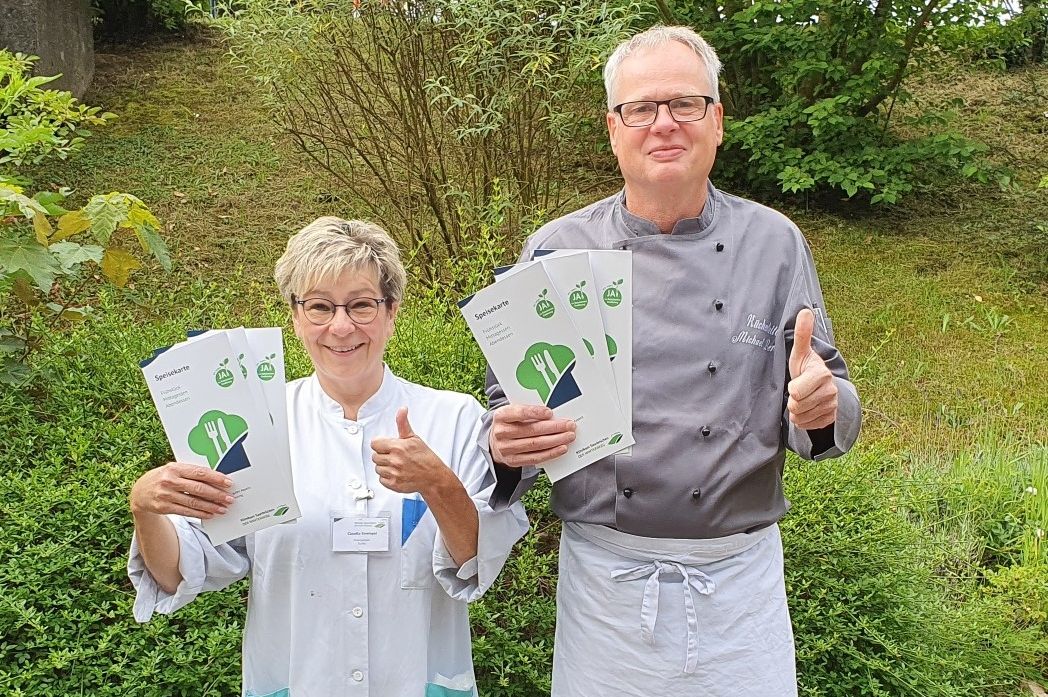 Küchenchef Michael Berres und Mitarbeiterin Claudia Strempel zeigen die neuen Speisekarten.
