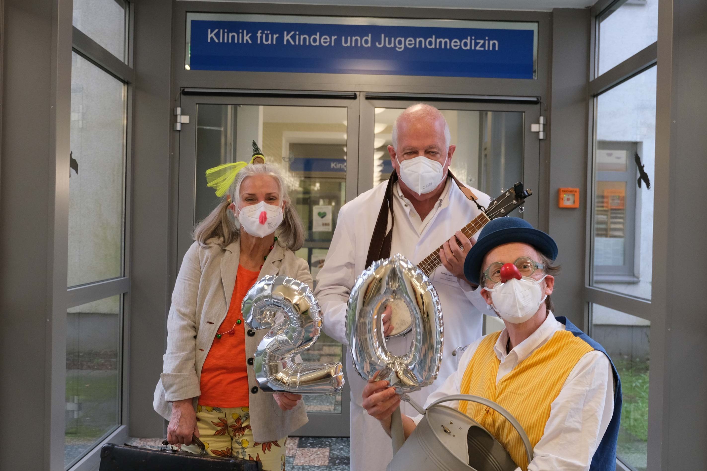 Zwei der Klinikclowns gemeinsam mit dem Chefarzt der Kinderklinik Prof. Dr. Jens Möller vor der Kinderklinik des Klinikums Saarbrücken