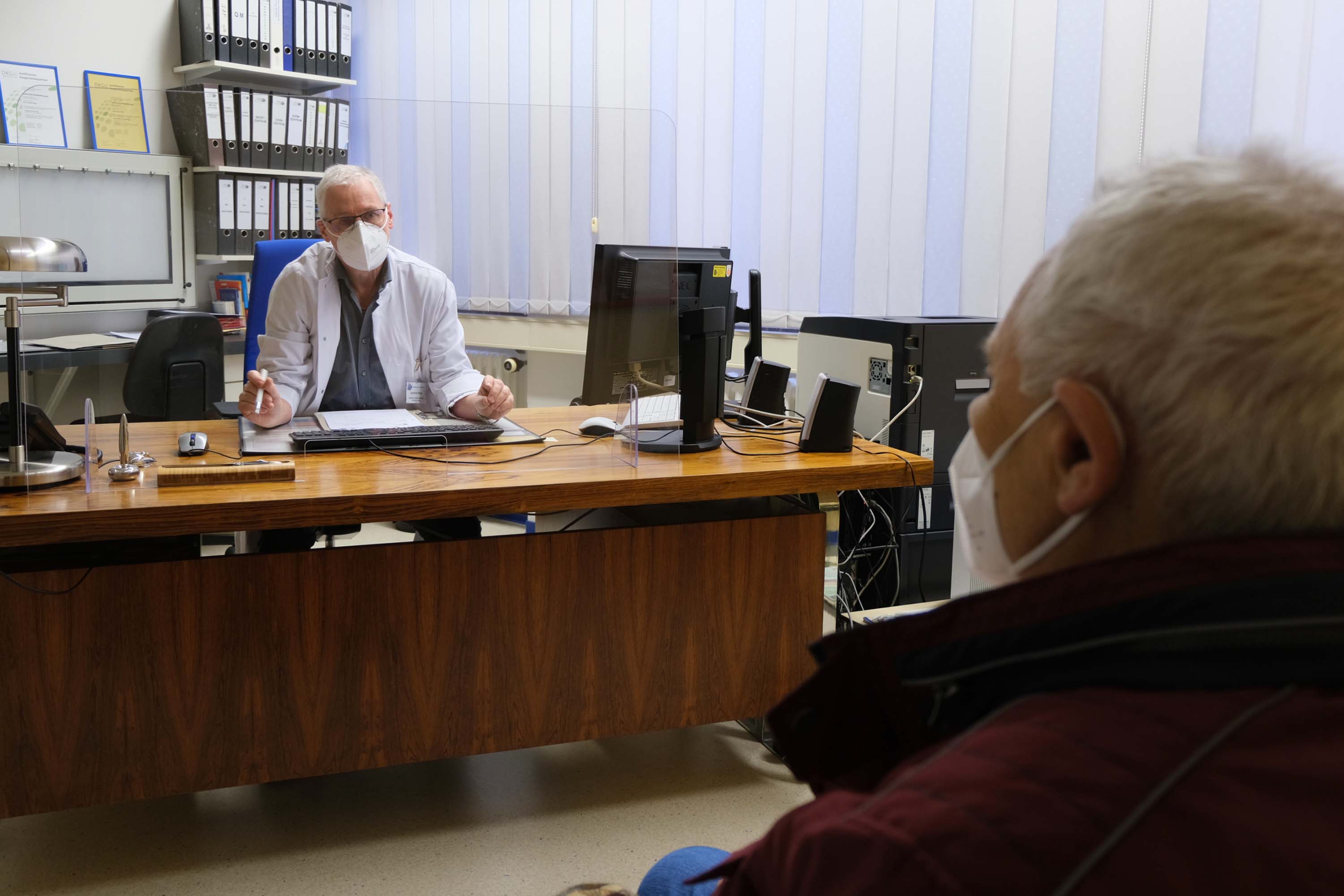 Ärztlicher Leiter der Strahlentherapie im Nachsorgegespräch mit einem Krebspatienten