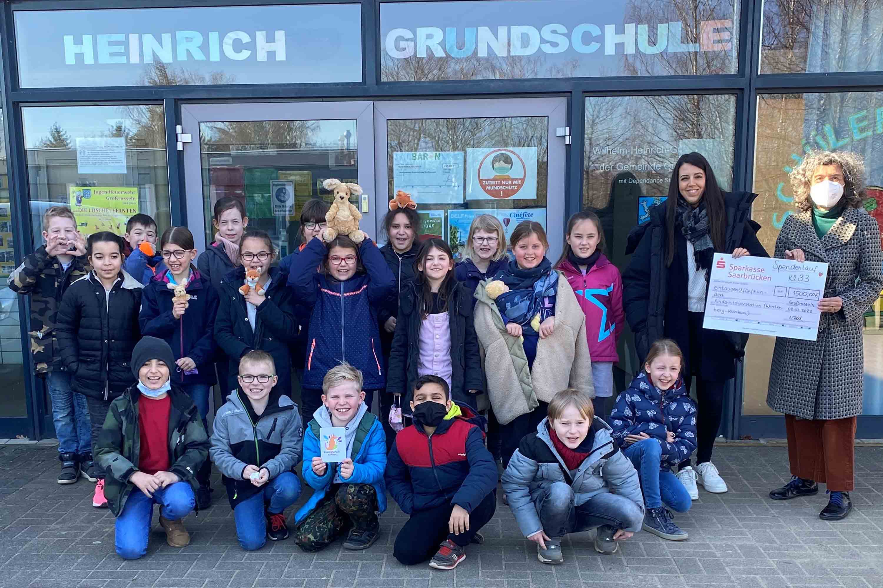 Gruppenfoto: Grundschule überreicht Spendenscheck